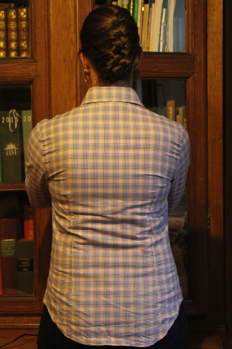 Jeune femme qui porte une chemise cintré à petits carreaux rose bleu