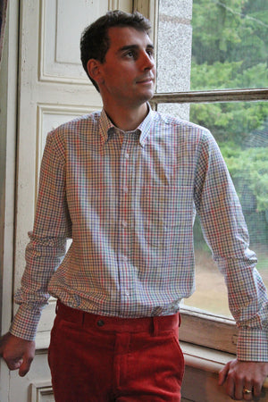 Jeune homme qui porte une chemise col boutonné 100% coton petits carreaux rouge bleu vert