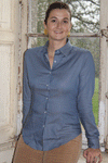 Jeune femme qui porte une chemise cintrée en coton de couleur bleu céramique avec des petits pois blanc 