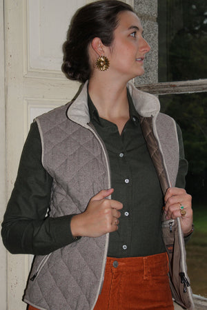 Jeune femme qui porte un gilet sans manche en laine matelassé chevron marron avec un col montant