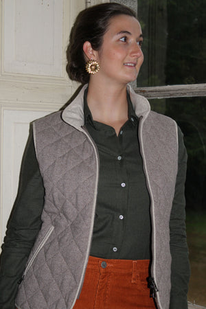 Jeune femme qui porte un gilet sans manche en laine matelassé chevron marron avec un col montant