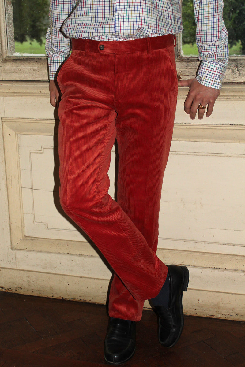 jeune homme qui porte un pantalon en velours côtelé couleur orange rouille