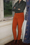 Jeune femme qui porte un pantalon en velours côtelé droit couleur orange rouille