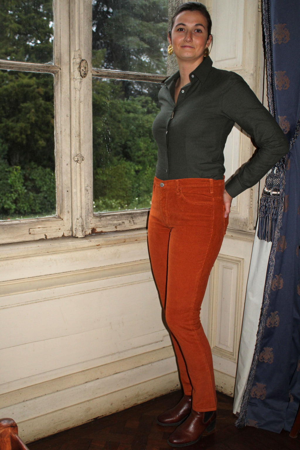Jeune femme qui porte un pantalon en velours côtelé droit couleur orange rouille