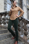 Jeune femme qui porte un pantalon en velour côtelé vert olive foncée
