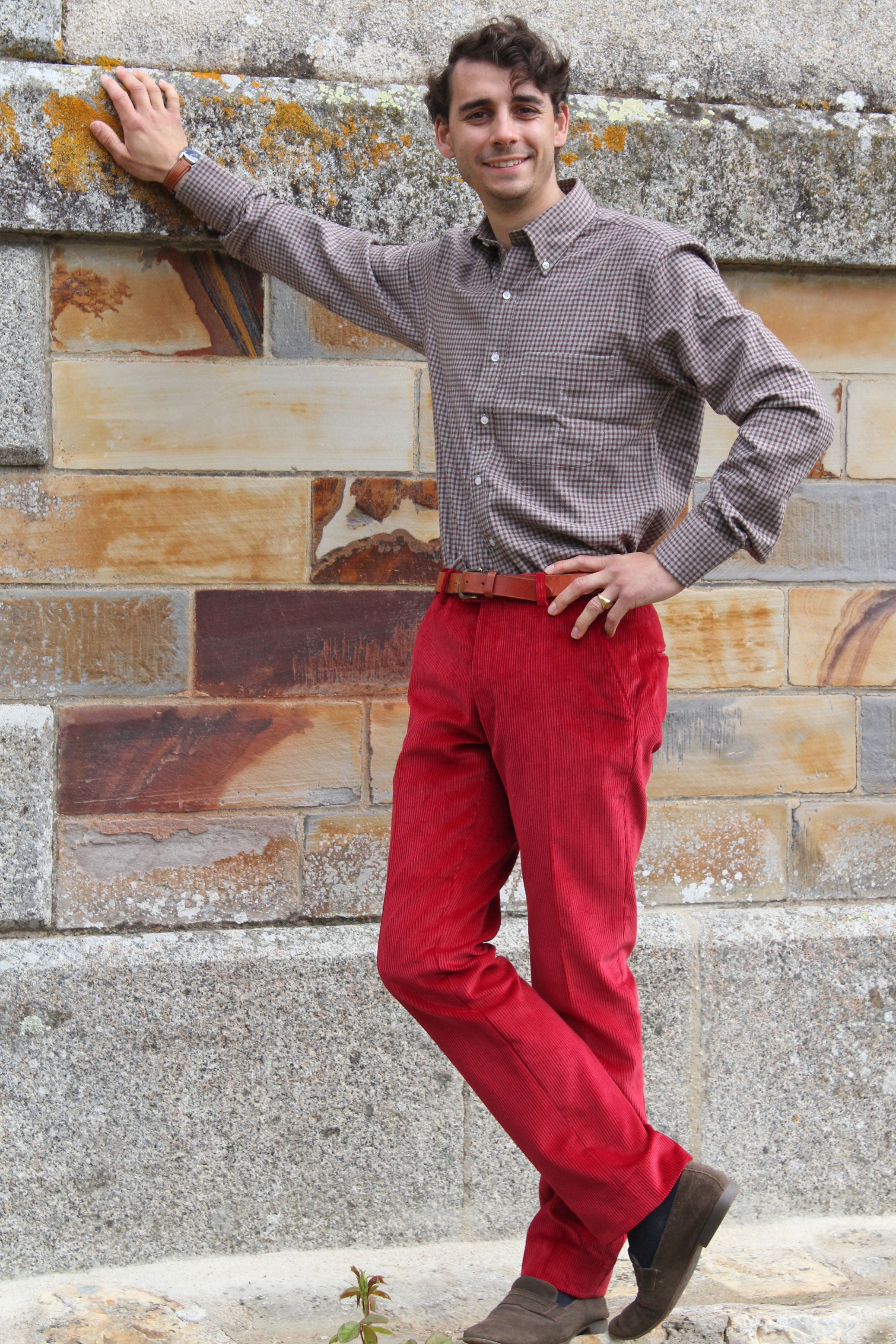 jeune homme qui porte un pantalon en velours cotelé rouge framboise