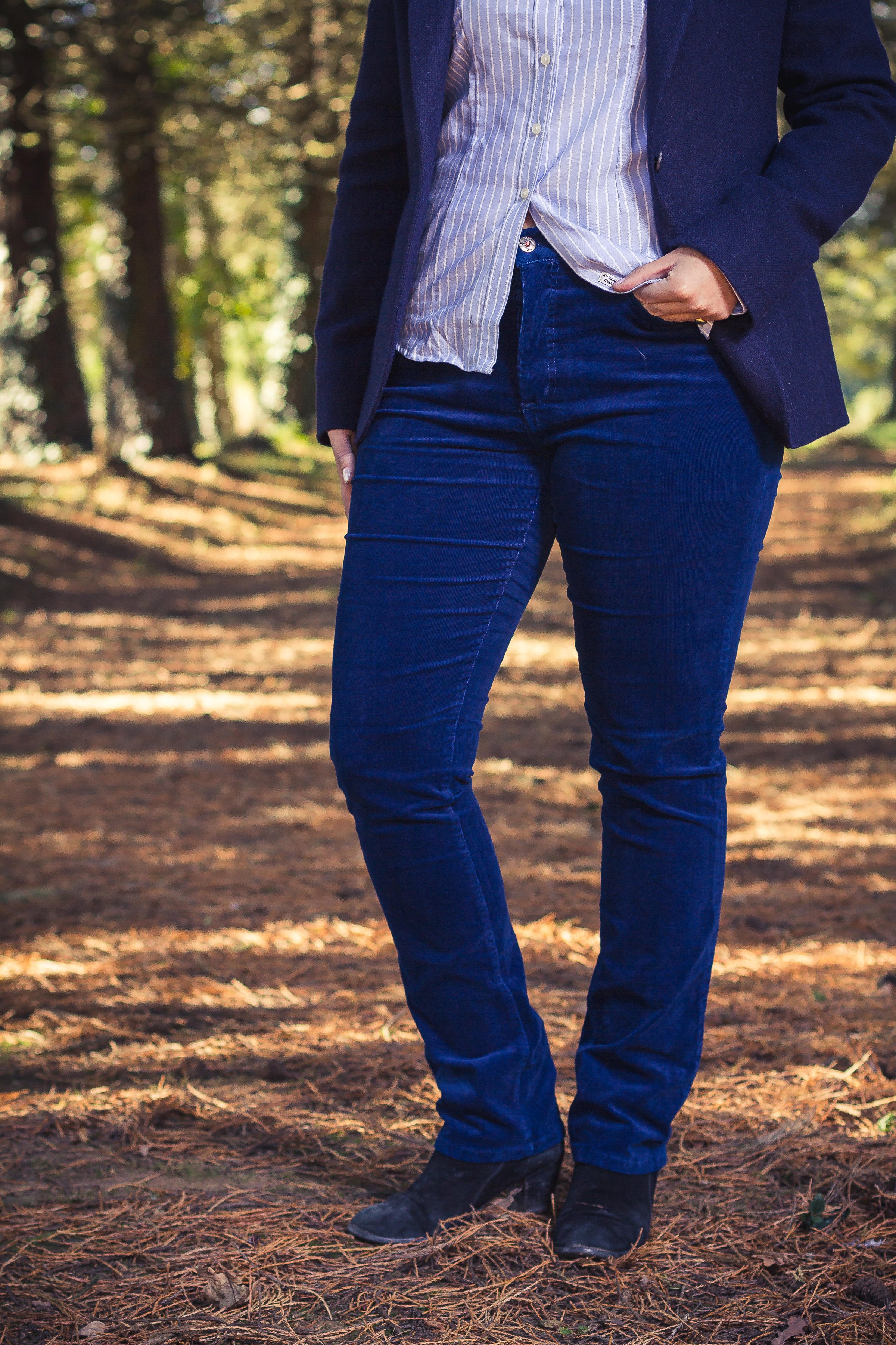 Jeune femme qui porte un pantalon en velours côtelé de couleur bleu marine