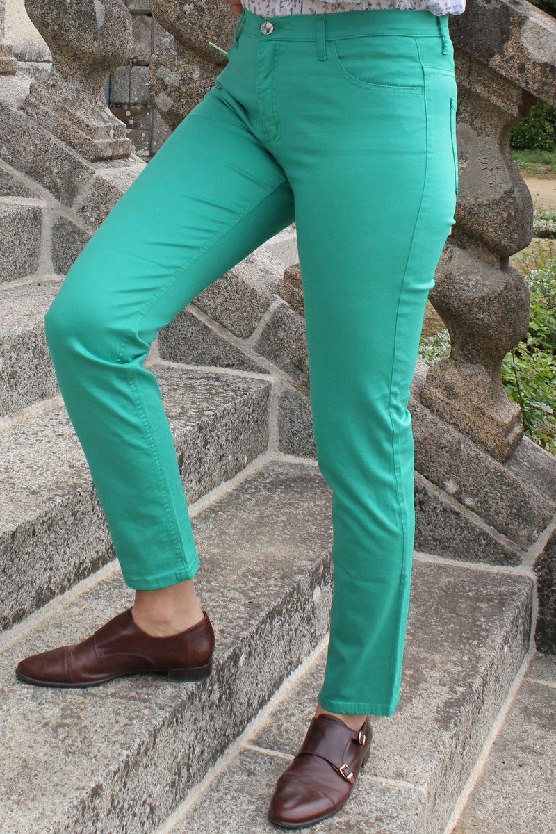 Jeune femme qui porte un pantalon en toile coupe droite de couleur émeraude. 