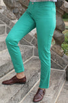 Jeune femme qui porte un pantalon en toile coupe droite de couleur émeraude. 
