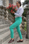 Jeune femme qui porte un pantalon en toile coupe droite de couleur émeraude. 