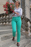Jeune femme qui porte un pantalon en toile coupe droite de couleur émeraude. 