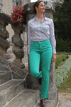 Jeune femme qui porte un pantalon en toile coupe droite de couleur émeraude. 