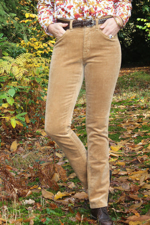 Jeune femme qui porte un pantalon en velours côtelé beige camel